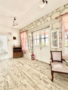 a living room with a stone wall and a door at Aişem By Hire in Alaçatı