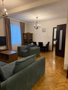 a living room with two couches and a dining room at Kobuleti apartment in Kobuleti