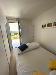 une chambre avec un lit blanc avec un oreiller bleu dans l'établissement Appartement LES PETITS PRINCES, à Agay 22 autres photos