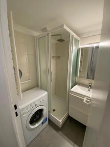 une salle de bains avec lave-linge et lavabo dans l'établissement Appartement LES PETITS PRINCES, à Agay