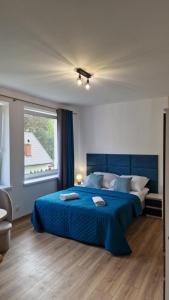 a bedroom with a blue bed and a window at Apartamenty Bliza in Ostrowo