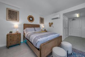 a bedroom with a large bed and two stools at Promenade Studio in Los Angeles