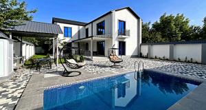 a house with a swimming pool in front of a house at View of the Mountain in Gabala