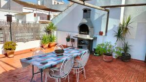 patio ze stołem i krzesłami oraz piecem do pizzy w obiekcie Casa Las Lomas w mieście Prado del Rey