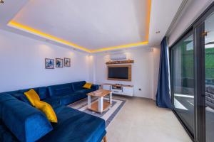 a living room with a blue couch and a tv at Villa Lovelet 2 in Kas