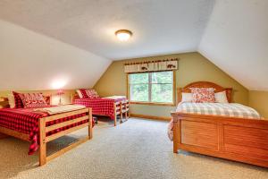 a attic bedroom with two beds and a window at Ski, Hike and Fish Chalet with Hot Tub in Conway in Conway