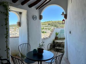 a patio with a table and chairs and two windows at Las casillas de la Villa ALEGRÍAS in Montefrío