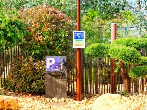a parking sign on a pole next to a fence at Cottage avec piscine au cœur du Saumur Champigny in Souzay-Champigny