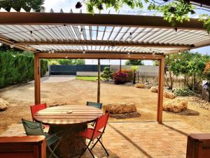 a patio with a table and chairs under a pergola at Cottage avec piscine au cœur du Saumur Champigny in Souzay-Champigny