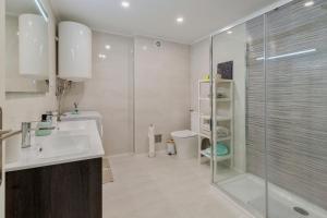 a bathroom with a shower and a sink and a toilet at Costa 27 Beach Apartment - By Y Concept in Costa da Caparica +24 photos