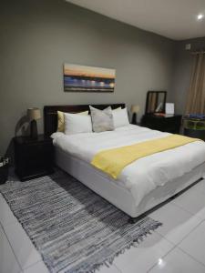 a bedroom with a large bed with a yellow blanket at The Penthouse in Port Edward +26 photos