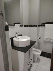 Un baño blanco con lavabo e inodoro. en The Penthouse, en Port Edward