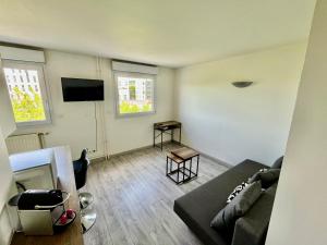 a living room with a couch and a flat screen tv at La Perle in Rouen