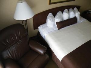 a bed and a chair in a hotel room at C'Mon Inn in Thief River Falls +10 photos