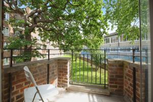 a white chair sitting on a balcony with a tree at bright flat near dulwich park in West Dulwich