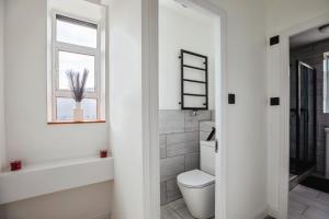 a bathroom with a toilet and a window at bright flat near dulwich park in West Dulwich +11 photos