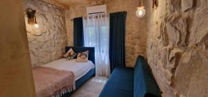 a bedroom with a bed and a stone wall at Iris 2 BR Apartment In Batroun in Batroûn