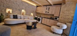 a living room with a white couch and a kitchen at Iris 2 BR Apartment In Batroun in Batroûn