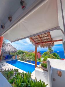 a view of a swimming pool with an umbrella at Villa Ballam 3, Balcones, bahías de Huatulco, Oax in Tangolunda