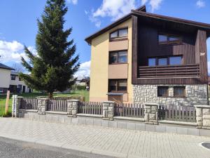 a house with a fence and a tree at Sárka in Štrba