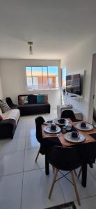 ein Wohnzimmer mit Tisch und Couch in der Unterkunft Ap 2 quartos tipo resort pé na areia 2 in Aracaju