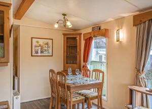 Un comedor con una mesa con copas de vino encima. en Tan-Y-Fron Holiday Park, en Dolgellau