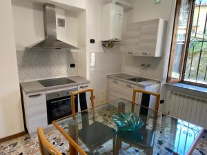 a kitchen with a glass table and chairs in it at Casa Franca - Vacation Apartment in San Pellegrino Terme