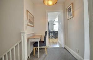 a hallway with a desk and a table with a chair at Lennox Lodge 2 in Portsmouth +13 photos