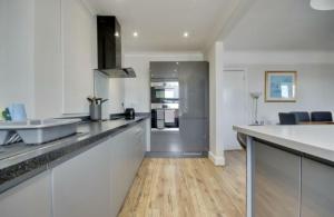 a kitchen with white walls and a wooden floor at Lennox Lodge 2 in Portsmouth