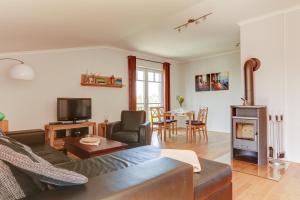 a living room with a couch and a fireplace at Ferienwohnungen Strandvilla Börgerende in Börgerende-Rethwisch