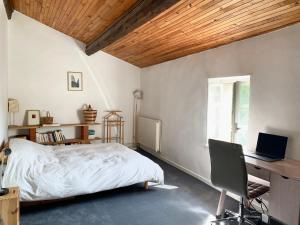 a bedroom with a bed and a desk with a laptop at House with garden - city center in Dieulefit