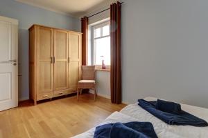 ein Schlafzimmer mit einem Bett, einem Stuhl und einem Fenster in der Unterkunft Ferienwohnungen Strandvilla Börgerende in Börgerende-Rethwisch
