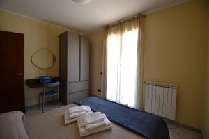 a bedroom with a bed with towels on it at Appartamento Camineve 1 in Loano