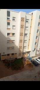 a large white building next to a parking lot at Apartamento en Rabat al lado del Mar in Oulad Akkou