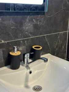 a bathroom sink with two cups on top of it at Apartman Z13, Ljubuški in Ljubuški +1 photo