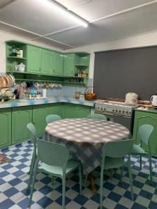 a kitchen with green cabinets and a table and chairs at Casa Syukur in Cukai
