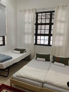 a bedroom with two beds and a window at Casa Syukur in Cukai