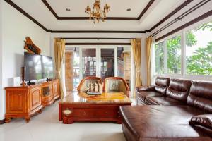 a living room with a couch and a table at Luxury Iconic Royal Boat Pool Villa North Pattaya in Pattaya Central