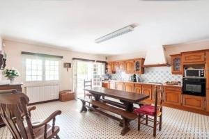 eine große Küche mit Holztisch und Stühlen in der Unterkunft Magnifique maison avec piscine in Bon-Encontre