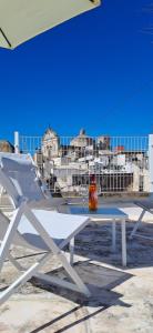a white picnic table with a drink sitting on it at Palazzo d'Itria - Luxury holiday in Valle d'Itria in Martina Franca