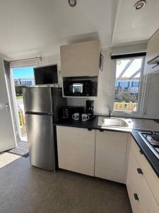 a kitchen with a stainless steel refrigerator and a sink at La Parenthèse du Phare in Le Portel +10 photos
