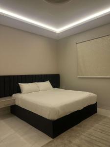 a bedroom with a bed in a room with a projector at ملاذ للشقق المفروشة 2 in Tabuk