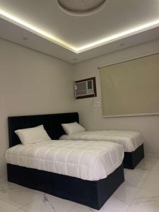 two beds in a hotel room with at ملاذ للشقق المفروشة 2 in Tabuk