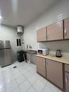 a kitchen with a refrigerator and a table in it at ملاذ للشقق المفروشة 2 in Tabuk