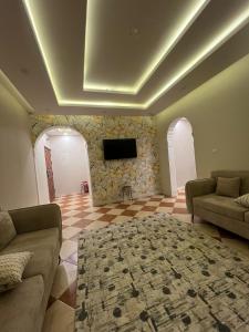 a living room with a couch and a tv on a wall at ملاذ للشقق المفروشة 2 in Tabuk