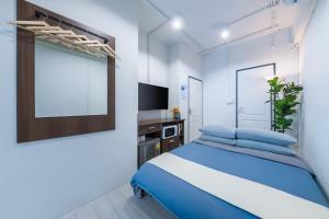 a bedroom with a blue bed and a tv at Petchaburi22 Apartments next to Platinum mall in Bangkok