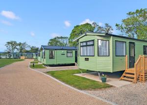 a row of green mobile homes in a park at York House Holiday Park in Thirsk