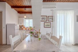 a kitchen and dining room with a table and chairs at Helianthos Villas in Douliana