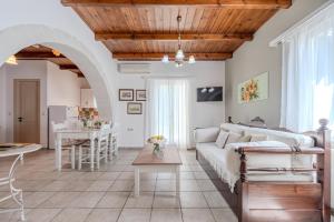 a living room with a couch and a table at Helianthos Villas in Douliana +38 photos
