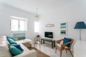 een woonkamer met een bank en een tv bij Fantástico ático en el casco antiguo en a la playa in Cádiz
